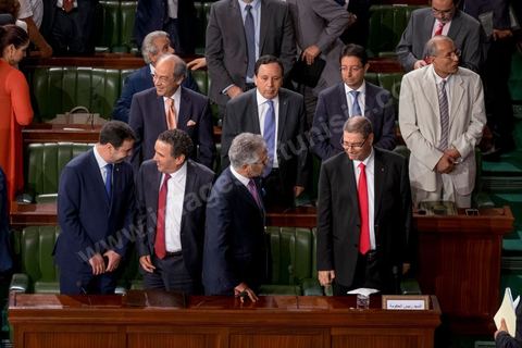 30 juillet 2016 : Le banc des ministres du gouvernement de Habib Essid. Après dix-huit mois à la tête du gouvernement tunisien, Habib Essid, technocrate âgé de 67 ans, n’est plus le premier ministre. L’Assemblée des représentants du peuple (ARP), réunie samedi 30 juillet à Tunis, a refusé par 118 voix sur 148 (3 pour et 27 abstentions) de renouveler sa confiance à M. Essid, qui l’avait sollicitée sans trop se faire d’illusions sur l’issue du vote. L’essentiel des députés affiliés aux quatre partis (Nidaa Tounès, Ennahda, Afek Tounès et Union Patriotique Libre) associés à la coalition gouvernementale dirigée par M. Essid ont voté contre la reconduction du premier ministre.Le départ de ce dernier solde le conflit qui l’oppose depuis deux mois au président de la République Béji Caïd Essebsi, âgé de 89 ans. Le 2 juin, le chef de l’Etat avait fragilisé la position de M. Essid en lançant l’idée d’un gouvernement d’« union nationale », une initiative justifiée à ses yeux par la nécessité d’ouvrir une phase plus offensive de l’action gouvernementale. Alors que la Tunisie est confrontée à une économique et sociale très difficile.