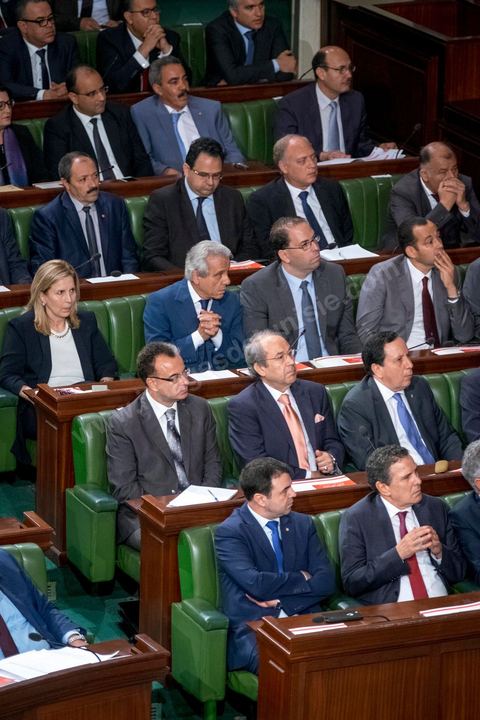 30 juillet 2016 : Le banc des ministres du gouvernement de Habib Essid. Après dix-huit mois à la tête du gouvernement tunisien, Habib Essid, technocrate âgé de 67 ans, n’est plus le premier ministre. L’Assemblée des représentants du peuple (ARP), réunie samedi 30 juillet à Tunis, a refusé par 118 voix sur 148 (3 pour et 27 abstentions) de renouveler sa confiance à M. Essid, qui l’avait sollicitée sans trop se faire d’illusions sur l’issue du vote. L’essentiel des députés affiliés aux quatre partis (Nidaa Tounès, Ennahda, Afek Tounès et Union Patriotique Libre) associés à la coalition gouvernementale dirigée par M. Essid ont voté contre la reconduction du premier ministre.Le départ de ce dernier solde le conflit qui l’oppose depuis deux mois au président de la République Béji Caïd Essebsi, âgé de 89 ans. Le 2 juin, le chef de l’Etat avait fragilisé la position de M. Essid en lançant l’idée d’un gouvernement d’« union nationale », une initiative justifiée à ses yeux par la nécessité d’ouvrir une phase plus offensive de l’action gouvernementale. Alors que la Tunisie est confrontée à une économique et sociale très difficile.