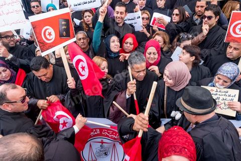 6 décémbre 2016 : Plus de 2.000 avocats ont manifesté mardi à Tunis contre les nouvelles dispositions fiscales qui leur ont été imposées dans le projet de budget 2017, actuellement examiné par le Parlement."Avec notre âme, avec notre sang nous défendrons le métier d'avocat", ont crié les manifestants en robe noire devant le siège du gouvernement à la Kasbah, dans le centre de Tunis, après une marche de quelques centaines de mètres."Les avocats sont en colère!", "Nous n'allons pas financer votre corruption", pouvait-on lire sur des pancartes brandies par les protestataires, dont beaucoup jugent les nouvelles mesures "injustes" et "inapplicables".En cause, des taxes imposées pour chaque dossier traité, pouvant être déduites de l'impôt sur le revenu et prévues dans le projet de loi de finances 2017.Ce mouvement ne fait toutefois pas l'unanimité, et sur les réseaux sociaux comme dans certains médias, les protestations des avocats ont été considérées comme une volonté de bénéficier d'un traitement spécial. Selon le webzine Inkyfada, qui a analysé des données officielles, 60% des avocats enregistrés n'ont pas déclaré d'impôts en 2015, et "les avocats en règle paient en moyenne 228 dinars (92 euros) d'impôt sur le revenu par mois".