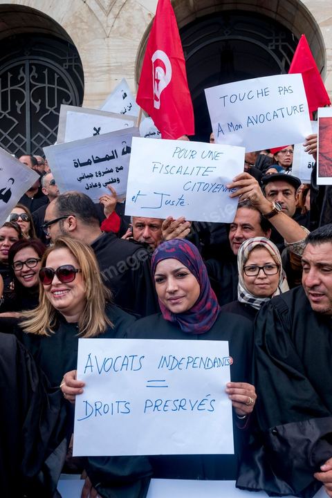 6 décémbre 2016 : Plus de 2.000 avocats ont manifesté mardi à Tunis contre les nouvelles dispositions fiscales qui leur ont été imposées dans le projet de budget 2017, actuellement examiné par le Parlement."Avec notre âme, avec notre sang nous défendrons le métier d'avocat", ont crié les manifestants en robe noire devant le siège du gouvernement à la Kasbah, dans le centre de Tunis, après une marche de quelques centaines de mètres."Les avocats sont en colère!", "Nous n'allons pas financer votre corruption", pouvait-on lire sur des pancartes brandies par les protestataires, dont beaucoup jugent les nouvelles mesures "injustes" et "inapplicables".En cause, des taxes imposées pour chaque dossier traité, pouvant être déduites de l'impôt sur le revenu et prévues dans le projet de loi de finances 2017.Ce mouvement ne fait toutefois pas l'unanimité, et sur les réseaux sociaux comme dans certains médias, les protestations des avocats ont été considérées comme une volonté de bénéficier d'un traitement spécial. Selon le webzine Inkyfada, qui a analysé des données officielles, 60% des avocats enregistrés n'ont pas déclaré d'impôts en 2015, et "les avocats en règle paient en moyenne 228 dinars (92 euros) d'impôt sur le revenu par mois".