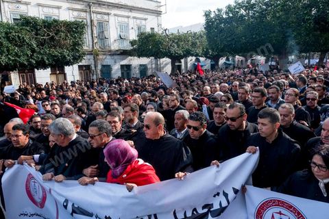 6 décémbre 2016 : Plus de 2.000 avocats ont manifesté mardi à Tunis contre les nouvelles dispositions fiscales qui leur ont été imposées dans le projet de budget 2017, actuellement examiné par le Parlement."Avec notre âme, avec notre sang nous défendrons le métier d'avocat", ont crié les manifestants en robe noire devant le siège du gouvernement à la Kasbah, dans le centre de Tunis, après une marche de quelques centaines de mètres."Les avocats sont en colère!", "Nous n'allons pas financer votre corruption", pouvait-on lire sur des pancartes brandies par les protestataires, dont beaucoup jugent les nouvelles mesures "injustes" et "inapplicables".En cause, des taxes imposées pour chaque dossier traité, pouvant être déduites de l'impôt sur le revenu et prévues dans le projet de loi de finances 2017.Ce mouvement ne fait toutefois pas l'unanimité, et sur les réseaux sociaux comme dans certains médias, les protestations des avocats ont été considérées comme une volonté de bénéficier d'un traitement spécial. Selon le webzine Inkyfada, qui a analysé des données officielles, 60% des avocats enregistrés n'ont pas déclaré d'impôts en 2015, et "les avocats en règle paient en moyenne 228 dinars (92 euros) d'impôt sur le revenu par mois".