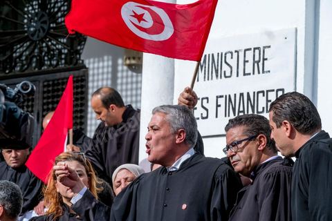 6 décémbre 2016 : Plus de 2.000 avocats ont manifesté mardi à Tunis contre les nouvelles dispositions fiscales qui leur ont été imposées dans le projet de budget 2017, actuellement examiné par le Parlement."Avec notre âme, avec notre sang nous défendrons le métier d'avocat", ont crié les manifestants en robe noire devant le siège du gouvernement à la Kasbah, dans le centre de Tunis, après une marche de quelques centaines de mètres."Les avocats sont en colère!", "Nous n'allons pas financer votre corruption", pouvait-on lire sur des pancartes brandies par les protestataires, dont beaucoup jugent les nouvelles mesures "injustes" et "inapplicables".En cause, des taxes imposées pour chaque dossier traité, pouvant être déduites de l'impôt sur le revenu et prévues dans le projet de loi de finances 2017.Ce mouvement ne fait toutefois pas l'unanimité, et sur les réseaux sociaux comme dans certains médias, les protestations des avocats ont été considérées comme une volonté de bénéficier d'un traitement spécial. Selon le webzine Inkyfada, qui a analysé des données officielles, 60% des avocats enregistrés n'ont pas déclaré d'impôts en 2015, et "les avocats en règle paient en moyenne 228 dinars (92 euros) d'impôt sur le revenu par mois".