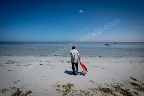 11 juin 2017 : Sur la plage de Ras Lemssa, au sud de Zarzis, Chemseddine, un gilet de migrant trouvé sur la plage, me montre l'endroit où une femme, puis en enfant et un homme ont été rertouvés ma seùaine dernière :'" ils étaient peut être de la même famille". A Zarzis, sur le littoral tunisien, frontalier de la Libye, Chemseddine Marzoug, ancien pêcheur au chomage, offre bénévolement depuis 10 ans une sépulture de sable aux noyés de la Méditerranée. Bénévoles pour le croissant rouge tunisien Chemseddine et son collègue Mohamed Trabelsi enterrent depuis 10 ans les corps des migrants trouvés en mer ou échoués sur les plages du sud tunisien dans un cimetière improvisé dans une décharge municipale. En cette saison de printemps, les morts sont très nombreux 27 corps ont été repêchés ce dernier mois. 