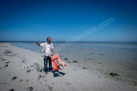 11 juin 2017 : Sur la plage de Ras Lemssa, au sud de Zarzis, Chemseddine, un gilet de migrant trouvé sur la plage, me montre l'endroit où une femme, puis en enfant et un homme ont été rertouvés ma seùaine dernière :'" ils étaient peut être de la même famille". A Zarzis, sur le littoral tunisien, frontalier de la Libye, Chemseddine Marzoug, ancien pêcheur au chomage, offre bénévolement depuis 10 ans une sépulture de sable aux noyés de la Méditerranée. Bénévoles pour le croissant rouge tunisien Chemseddine et son collègue Mohamed Trabelsi enterrent depuis 10 ans les corps des migrants trouvés en mer ou échoués sur les plages du sud tunisien dans un cimetière improvisé dans une décharge municipale. En cette saison de printemps, les morts sont très nombreux 27 corps ont été repêchés ce dernier mois. 