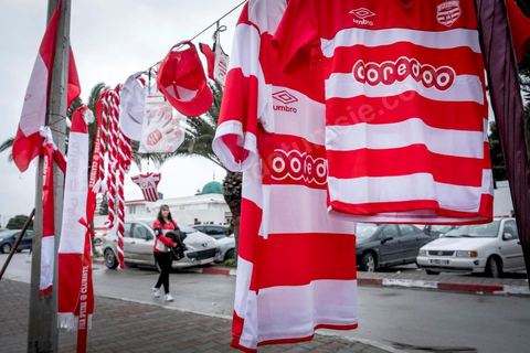 18 février 2018 : Devant le Parc A, centre d'entrainement du Club Africain, le merchandising se fait dans la rue avant le départ pour le stade. A Tunis c'est le grand jour celui du Derby Foot, le match entre les deux meilleures équipes actuelles du championnat et les deux équipes phares de Tunis, le Club Africain (CA) contre l'Espérance de Tunis (EST) au grand stade de Radès dans la banlieue sud de Tunis. Ce match retour est à l'avantage du CA qui dispose de la billetterie. Au vu des nombreux affrontements de supporters et des groupes d'ultras dans les stades entre eux et avec la police, seulement 23000 billets sont mis en vente (pour une capacité de 60000) dont 1200 pour l'EST mais qui ne seront qu'une petite cinquantaine dans la tribune sud. Le match se terminera par la victoire surprise du CA sur le score de 2 à 1. 