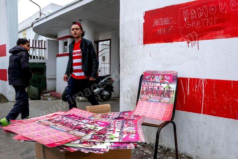 18 février 2018 : Devant le Parc A, centre d'entrainement du Club Africain, le merchandising se fait dans la rue avant le départ pour le stade. A Tunis c'est le grand jour celui du Derby Foot, le match entre les deux meilleures équipes actuelles du championnat et les deux équipes phares de Tunis, le Club Africain (CA) contre l'Espérance de Tunis (EST) au grand stade de Radès dans la banlieue sud de Tunis. Ce match retour est à l'avantage du CA qui dispose de la billetterie. Au vu des nombreux affrontements de supporters et des groupes d'ultras dans les stades entre eux et avec la police, seulement 23000 billets sont mis en vente (pour une capacité de 60000) dont 1200 pour l'EST mais qui ne seront qu'une petite cinquantaine dans la tribune sud. Le match se terminera par la victoire surprise du CA sur le score de 2 à 1. 