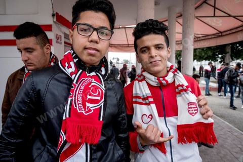 18 février 2018 : Au parc A du CA, les supporters se retrouvent et font leurs derniers achats de banderolles et écharpes avantd e rejoindre le stade pour le match. A Tunis c'est le grand jour celui du Derby Foot, le match entre les deux meilleures équipes actuelles du championnat et les deux équipes phares de Tunis, le Club Africain (CA) contre l'Espérance de Tunis (EST) au grand stade de Radès dans la banlieue sud de Tunis. Ce match retour est à l'avantage du CA qui dispose de la billetterie. Au vu des nombreux affrontements de supporters et des groupes d'ultras dans les stades entre eux et avec la police, seulement 23000 billets sont mis en vente (pour une capacité de 60000) dont 1200 pour l'EST mais qui ne seront qu'une petite cinquantaine dans la tribune sud. Le match se terminera par la victoire surprise du CA sur le score de 2 à 1. 