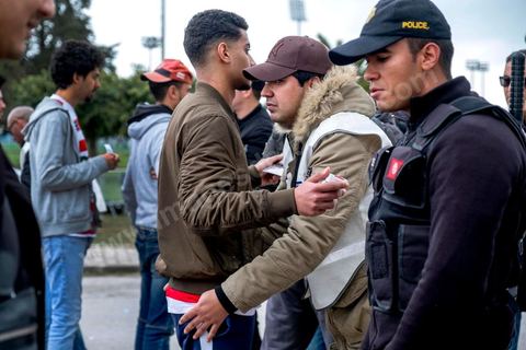 18 février 2018 : L'entrée au stade et plus particulièrement des accès aux tribunes nord, celles des ultras du CA, nécessite discipline, controles et fouilles par la police. Les derniers matchs ayant connu beaucoup de violences et affrontements des ultras avec la police, les conditions d'entrée au stade sont rigoureuses et sous la surveillance de près de 3000 policiers. A Tunis c'est le grand jour celui du Derby Foot, le match entre les deux meilleures équipes actuelles du championnat et les deux équipes phares de Tunis, le Club Africain (CA) contre l'Espérance de Tunis (EST) au grand stade de Radès dans la banlieue sud de Tunis. Ce match retour est à l'avantage du CA qui dispose de la billetterie. Au vu des nombreux affrontements de supporters et des groupes d'ultras dans les stades entre eux et avec la police, seulement 23000 billets sont mis en vente (pour une capacité de 60000) dont 1200 pour l'EST mais qui ne seront qu'une petite cinquantaine dans la tribune sud. Le match se terminera par la victoire surprise du CA sur le score de 2 à 1. 
