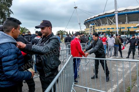 18 février 2018 : L'entrée au stade et plus particulièrement des accès aux tribunes nord, celles des ultras du CA, nécessite discipline, controles et fouilles par la police. Les derniers matchs ayant connu beaucoup de violences et affrontements des ultras avec la police, les conditions d'entrée au stade sont rigoureuses et sous la surveillance de près de 3000 policiers. A Tunis c'est le grand jour celui du Derby Foot, le match entre les deux meilleures équipes actuelles du championnat et les deux équipes phares de Tunis, le Club Africain (CA) contre l'Espérance de Tunis (EST) au grand stade de Radès dans la banlieue sud de Tunis. Ce match retour est à l'avantage du CA qui dispose de la billetterie. Au vu des nombreux affrontements de supporters et des groupes d'ultras dans les stades entre eux et avec la police, seulement 23000 billets sont mis en vente (pour une capacité de 60000) dont 1200 pour l'EST mais qui ne seront qu'une petite cinquantaine dans la tribune sud. Le match se terminera par la victoire surprise du CA sur le score de 2 à 1. 