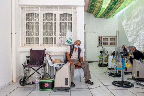 23 juillet 2021 : dans le cabinet du Dr Jalel Ben Youssef, medecin généraliste dans la petite ville d'Utique au nord de Tunis, c'est un petit hopital de campagne qu'il a aménagé. En cet après-midi, c'est une petite quinzaine de patients qui occupent le patio, la salle d'attente ou le bureau du medecin pour profiter des respirateurs d'oxygène et traitements offerts par le généraliste grâce à des dons de privés. Il offre ses services médicaux gratuits dans une région agricole loin des hopitaux. Chaque soir les malades dans le besoin repartent chez eux avec les respirateurs. 