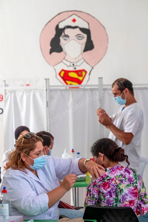 08 aout 2021 : Dans un centre de vaccination à la maison de la culture de l'Ariana, banlieue de Tunis. Suite à l'arrivée massive de dons en vaccin, près de 6 millions de doses, et le retard important de la vaccination en Tunisie, il a été organisé aujourd'hui une journéé nationale de vaccination des plus de 40 ans sur l'ensemble du territoire. Les tunisiens ont répondus massivement à l'appel et grâce à l'aide de très nombreux bénévoles, de l'armée et de la police, du personnel de santé, il a été comptabilisé plus de 200 000 injections à midi. 