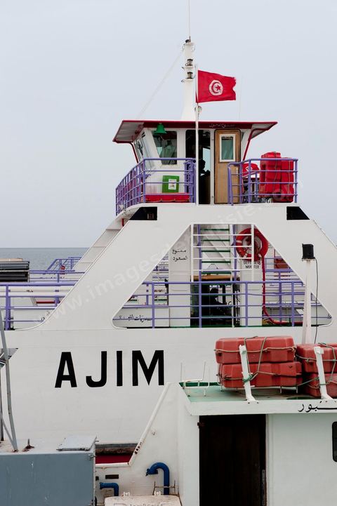 Adjim, sur la côte sud-ouest de Djerba, est le point de départ du bac qui relie l'île au continent, à Jorf, à travers le chenal séparant Djerba de la Tunisie continentale. Le port, encore marqué par une activité de pêche traditionnelle, offre des ambiances changeantes au fil de la journée, entre lever et coucher de soleil sur la mer, bateaux amarrés et silhouettes des jetées.