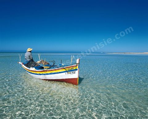 Adjim, sur la côte sud-ouest de Djerba, est le point de départ du bac qui relie l'île au continent, à Jorf, à travers le chenal séparant Djerba de la Tunisie continentale. Le port, encore marqué par une activité de pêche traditionnelle, offre des ambiances changeantes au fil de la journée, entre lever et coucher de soleil sur la mer, bateaux amarrés et silhouettes des jetées.