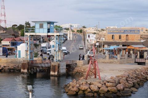 Adjim, sur la côte sud-ouest de Djerba, est le point de départ du bac qui relie l'île au continent, à Jorf, à travers le chenal séparant Djerba de la Tunisie continentale. Le port, encore marqué par une activité de pêche traditionnelle, offre des ambiances changeantes au fil de la journée, entre lever et coucher de soleil sur la mer, bateaux amarrés et silhouettes des jetées.