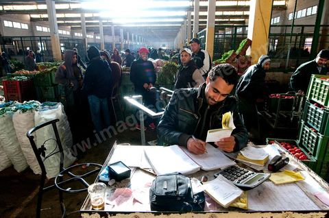 Vendeur faisant ses comptes à la Halle aux fruits et légumes du marché de gros de Tunis à El Mourouj