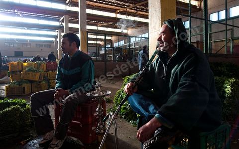 Vendeur fumant la chicha à la Halle aux fruits et légumes du marché de gros de Tunis à El Mourouj