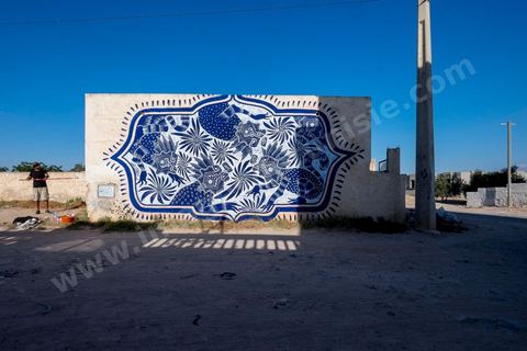 Oeuvre de l'artiste mexicain CURIOT pour le Projet DjerbaHood : après la Tour Paris 13, la team Itinerrance dépose ses valises dans un village traditionnel de l’île de Djerba, Erriadh. Depuis le début du mois de juillet, le village d’Erriadh se métamorphose petit à petit pour devenir un véritable musée à ciel ouvert. Une sélection d’artistes des quatre coins du monde ont été invités à s’exprimer dans ce décor unique à l’architecture authentique : murs blancs, portes bleues turquoises, dômes, veilles constructions et divers lieux abandonnés, autant de possibilités qui donneront naissance à des créations uniques aux couleurs locales.
