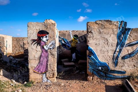 Oeuvres de l'artiste brésilien TINHO (personnages) et l'artiste portugais PANTONIO (lapins) pour le Projet DjerbaHood : après la Tour Paris 13, la team Itinerrance dépose ses valises dans un village traditionnel de l’île de Djerba, Erriadh. Depuis le début du mois de juillet, le village d’Erriadh se métamorphose petit à petit pour devenir un véritable musée à ciel ouvert. Une sélection d’artistes des quatre coins du monde ont été invités à s’exprimer dans ce décor unique à l’architecture authentique : murs blancs, portes bleues turquoises, dômes, veilles constructions et divers lieux abandonnés, autant de possibilités qui donneront naissance à des créations uniques aux couleurs locales.
