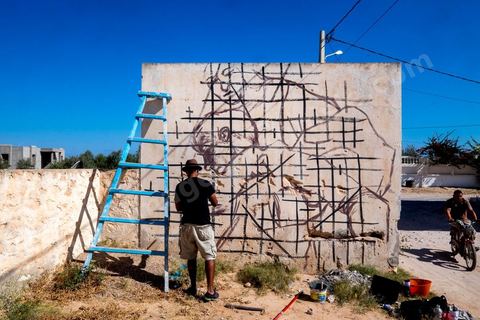 Oeuvres de l'artiste dominicain EVOCA1 pour le Projet DjerbaHood : après la Tour Paris 13, la team Itinerrance dépose ses valises dans un village traditionnel de l’île de Djerba, Erriadh. Depuis le début du mois de juillet, le village d’Erriadh se métamorphose petit à petit pour devenir un véritable musée à ciel ouvert. Une sélection d’artistes des quatre coins du monde ont été invités à s’exprimer dans ce décor unique à l’architecture authentique : murs blancs, portes bleues turquoises, dômes, veilles constructions et divers lieux abandonnés, autant de possibilités qui donneront naissance à des créations uniques aux couleurs locales.
