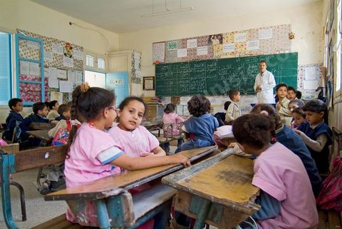 Ecole primaire à Houmt Souk sur l'île de Djerba - ecoliers dans leur école primaire, salle de classe, cour de récréation, écoliers en blouse rose et bleu, instituteur, cours de classe de primaire en Tunisie. enfants dasns sale de classe d'une école