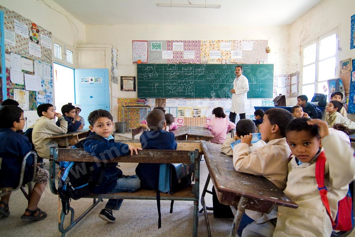 Ecole primaire à Houmt Souk sur l'île de Djerba - ecoliers dans leur école primaire, salle de classe, cour de récréation, écoliers en blouse rose et bleu, instituteur, cours de classe de primaire en Tunisie. enfants dasns sale de classe d'une école
