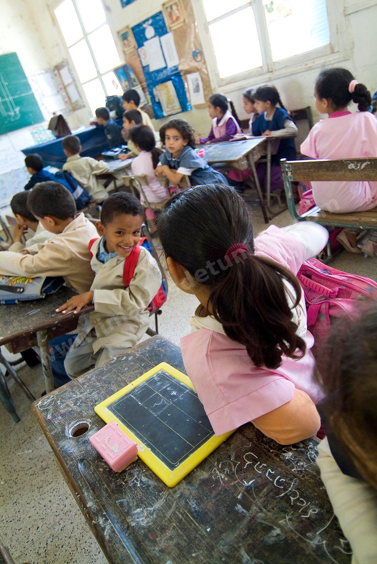 Ecole primaire à Houmt Souk sur l'île de Djerba - ecoliers dans leur école primaire, salle de classe, cour de récréation, écoliers en blouse rose et bleu, instituteur, cours de classe de primaire en Tunisie. enfants dasns sale de classe d'une école