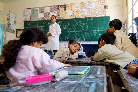 Ecole primaire à Houmt Souk sur l'île de Djerba - ecoliers dans leur école primaire, salle de classe, cour de récréation, écoliers en blouse rose et bleu, instituteur, cours de classe de primaire en Tunisie. enfants dasns sale de classe d'une école