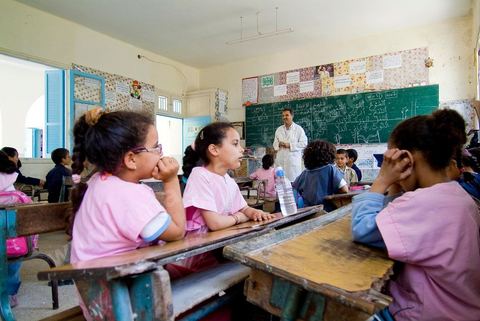 Ecole primaire à Houmt Souk sur l'île de Djerba - ecoliers dans leur école primaire, salle de classe, cour de récréation, écoliers en blouse rose et bleu, instituteur, cours de classe de primaire en Tunisie. enfants dasns sale de classe d'une école
