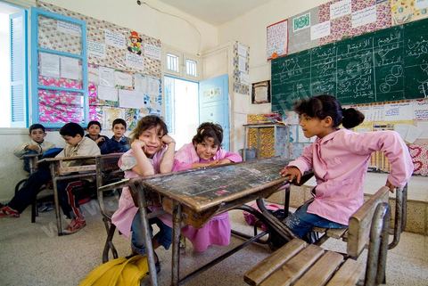 Ecole primaire à Houmt Souk sur l'île de Djerba - ecoliers dans leur école primaire, salle de classe, cour de récréation, écoliers en blouse rose et bleu, instituteur, cours de classe de primaire en Tunisie. enfants dasns sale de classe d'une école