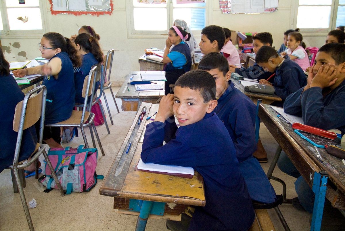 Ecole primaire à Houmt Souk sur l'île de Djerba - ecoliers dans leur école primaire, salle de classe, cour de récréation, écoliers en blouse rose et bleu, instituteur, cours de classe de primaire en Tunisie. enfants dasns sale de classe d'une école