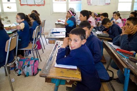 Ecole primaire à Houmt Souk sur l'île de Djerba - ecoliers dans leur école primaire, salle de classe, cour de récréation, écoliers en blouse rose et bleu, instituteur, cours de classe de primaire en Tunisie. enfants dasns sale de classe d'une école