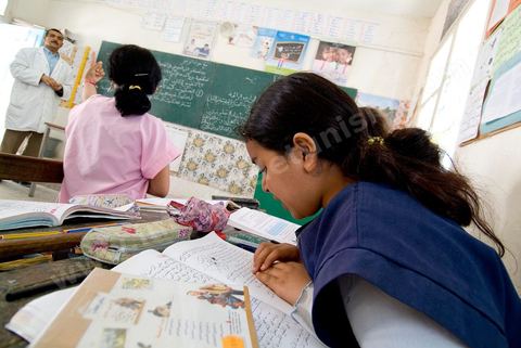 Ecole primaire à Houmt Souk sur l'île de Djerba - ecoliers dans leur école primaire, salle de classe, cour de récréation, écoliers en blouse rose et bleu, instituteur, cours de classe de primaire en Tunisie. enfants dasns sale de classe d'une école