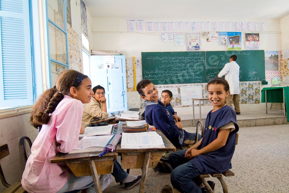 Ecole primaire à Houmt Souk sur l'île de Djerba - ecoliers dans leur école primaire, salle de classe, cour de récréation, écoliers en blouse rose et bleu, instituteur, cours de classe de primaire en Tunisie. enfants dasns sale de classe d'une école