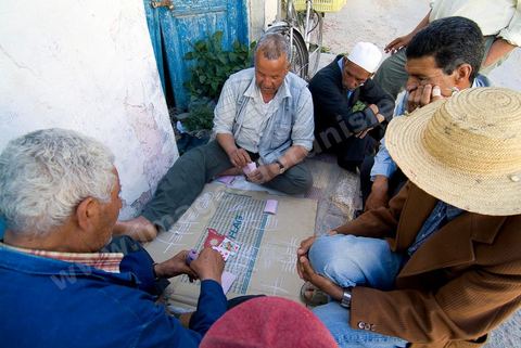Hommes jouant aux cartes dans la rue du quartier juif de Hara Kebira dans la banlieue de Houmt Souk sur l'île de Djerba