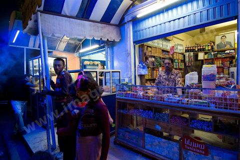 Restaurant et échoppes de fruits secs dans la rue du quartier juif de Hara Kebira dans la banlieue de Houmt Souk sur l'île de Djerba