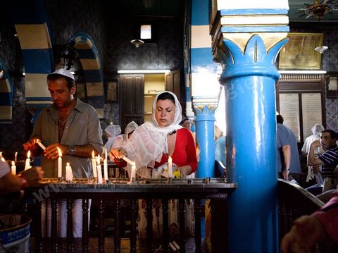 Pelerins brulant des cierges et faisant des voeux dans la synagogue de la Ghriba durant le pelerinage juif annuel au village de Erriadh ou Hara Sghira sur l'ile de djerba