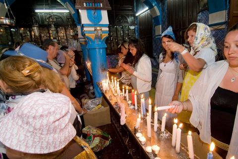 Pelerins brulant des cierges et faisant des voeux dans la synagogue de la Ghriba durant le pelerinage juif annuel au village de Erriadh ou Hara Sghira sur l'ile de djerba