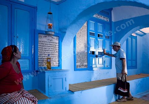 Pelerins juifs déposant des cierges et priant dans une petite synagogue bleue à Hara Sghira Erriadh durant le pelerinage juif annuel au village de Erriadh ou Hara Sghira sur l'ile de djerba
