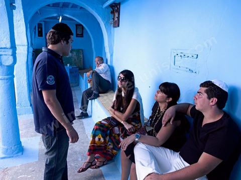 Pelerins juifs déposant des cierges et priant dans une petite synagogue bleue à Hara Sghira Erriadh durant le pelerinage juif annuel au village de Erriadh ou Hara Sghira sur l'ile de djerba