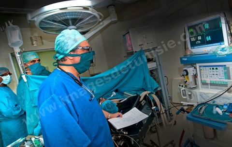 Le Dr Tahar Khalfallah (fond à gauche), chirurgien, et le Dr Mohamed Salah Ben Ammar (au premier plan), anesthésiste, durant une opération chirurgicale au bloc opératoire à l'hopital Mongi Slim de la Marsa