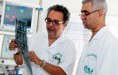 Le Dr Tahar Khalfallah (premier plan), chirurgien, et le Dr Mohamed Salah Ben Ammar (au second plan), anesthésiste, durant une consultation auprès d'un patient au service réanimation à l'hopital Mongi Slim de la Marsa