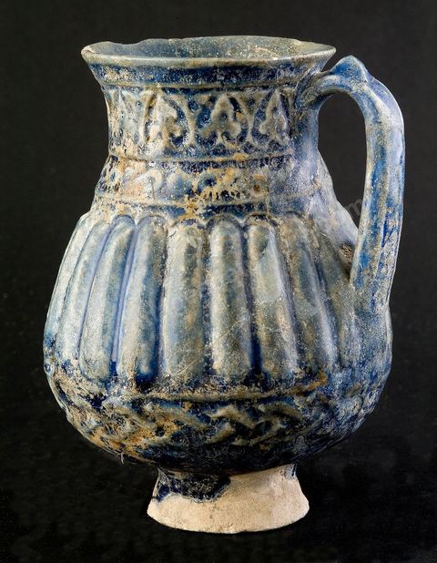 PICHET MOULÉIraq ou Perse, époque abbaside, 8  - 9  siècle.Cette céramique moulée à la panse cannelée et au col muni d'anneaux dérive directementd'un modèle en métal.