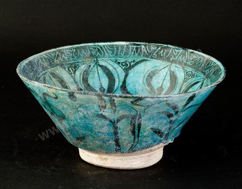 COUPE AUX FLEURONS.Syrie, attribuée à Raqqa, 13  siècle.Céramique silicieuse, large frise de huit fleurons bordée d'une frise haute imitant une écriture.
