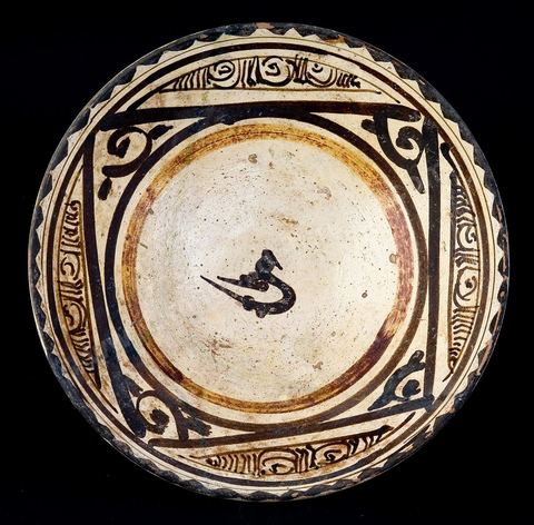 COUPE À L'ESQUISSE D'OISEAU. Perse,12  siècle.La disposition en carré et les motifs de remplissage évoquent une composition graphique. L'oiseau, au centre, est comme une lettre de l'alphabet ou un mot stylisé.Si le répertoire est bien géométrique, floral et animalier, le trait général est proche de la manière du calligraphe. Il s'en dégage une sorte d'image écrite. Le mot 'Khat' en arabe, désigne autant la ligne, l'esquisse que l'écriture.Le carré rappelle, par ailleurs, les carreaux de revêtement céramique, disposés, droits ou en carrés sur la pointe.