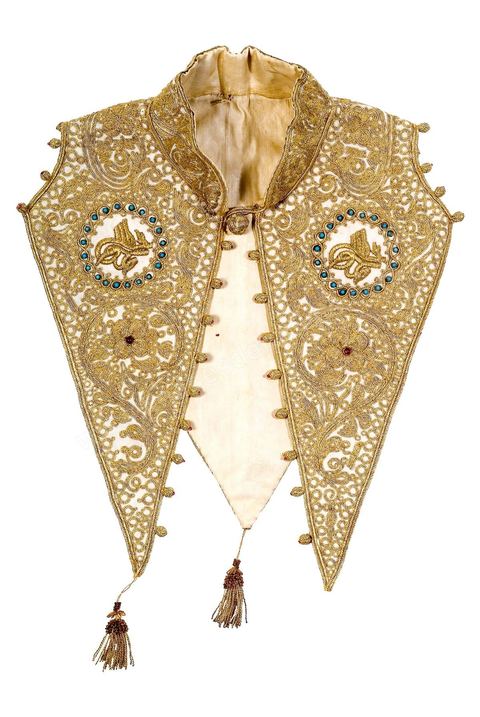 CAPE / GILET SANS MANCHE.Algérie, Oran, 19  siècle.En feutrine de laine. Brodé de fil doré et orné de deux médaillons renferment un motif graphique inspiré de la'Tughra' ottomane.Salle des Arts du Maghreb - Musée Lalla Hadria - Parc Djerba Explore