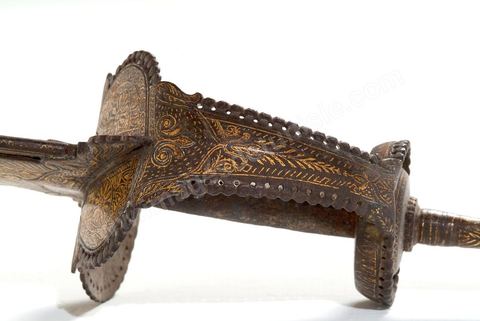 ÉPÉE / 'KHANDA'Perse (safavide) ou Inde (moghole), 18  siècle.La garde à large branche se prolonge jusqu'au tiers de la lame. Décor floral damasquiné d'or, et lame damassée. - Musée Lella Hadria à Djerba Explore