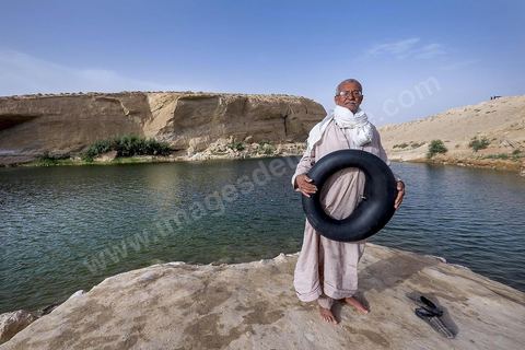 Belgacem came with some friends to go swimming in the lake at "Gafsa Beach." Since he didn't know how to swim, he made a float out of an inner tube.