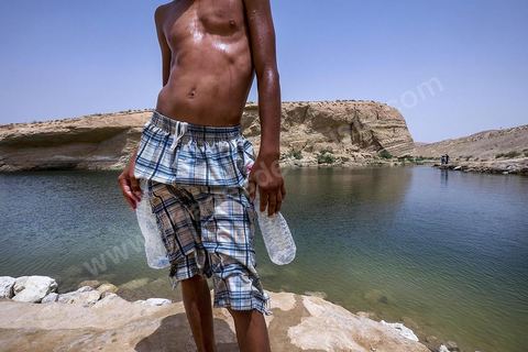 Anouar (17 ans) et Bilel (15 ans) vienent régulièrement depuis juillet se baigner dans lac de "Gafsa Beach". Ils viennent en stop de Moulares à une vingtaine de km du lac. Bilel a confectionné une bouée grâce à deux bouteille en plastique attachée à son short.