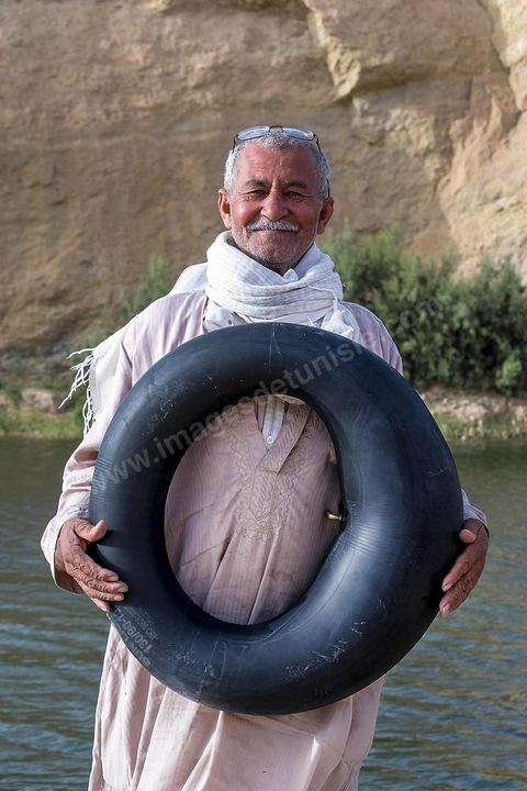 Belgacem came with some friends to go swimming in the lake at "Gafsa Beach." Since he didn't know how to swim, he made a float out of an inner tube.