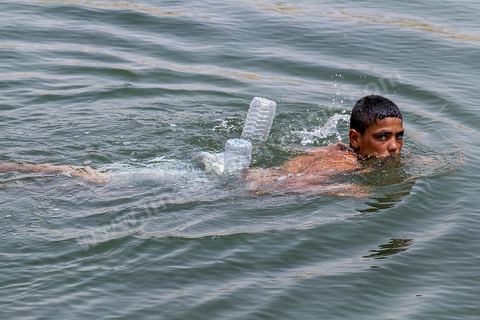 Anouar (17 ans) et Bilel (15 ans) vienent régulièrement depuis juillet se baigner dans lac de "Gafsa Beach". Ils viennent en stop de Moulares à une vingtaine de km du lac. Bilel a confectionné une bouée grâce à deux bouteille en plastique attachée à son short.